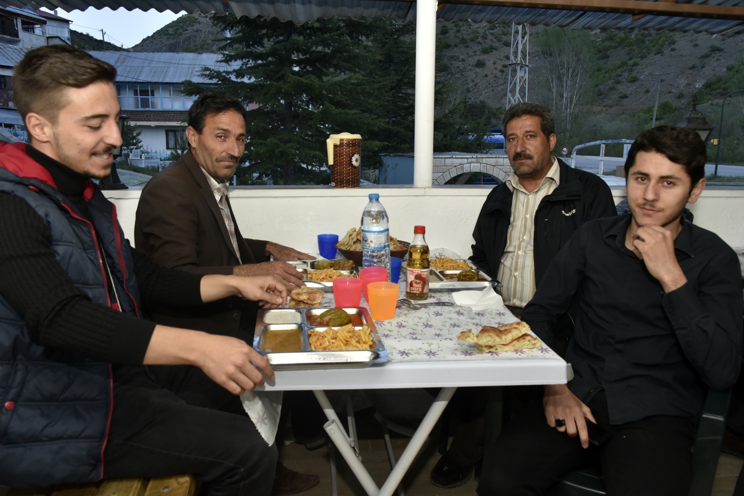 Merhum Aşkın’ın işlek bir karayolu kenarındaki köy kahvesinde bir iftar saatinde kamyon sürücüsünün ekmek-zeytinle iftar yaptığı görmesinin ardından başlayan gelenek ilk yıllarda köylülerin evlerinde yemek yaparak getirmesiyle başladı.